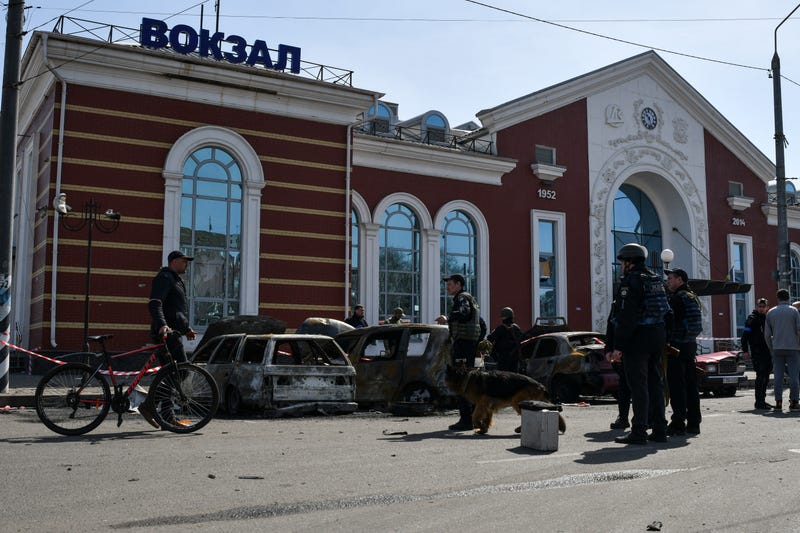 Ukrainian servicemen stand next to damaged cars after Russian shelling at the railway station in Kramatorsk, Ukraine, Friday, April 8, 2022