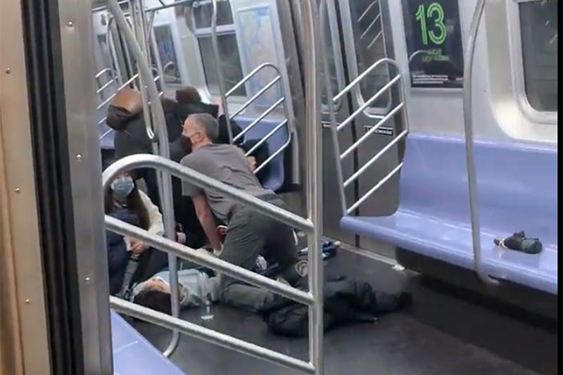 This photo provided by Will B Wylde, a person is aided in a subway car in Brooklyn on Tuesday, April 12, 2022