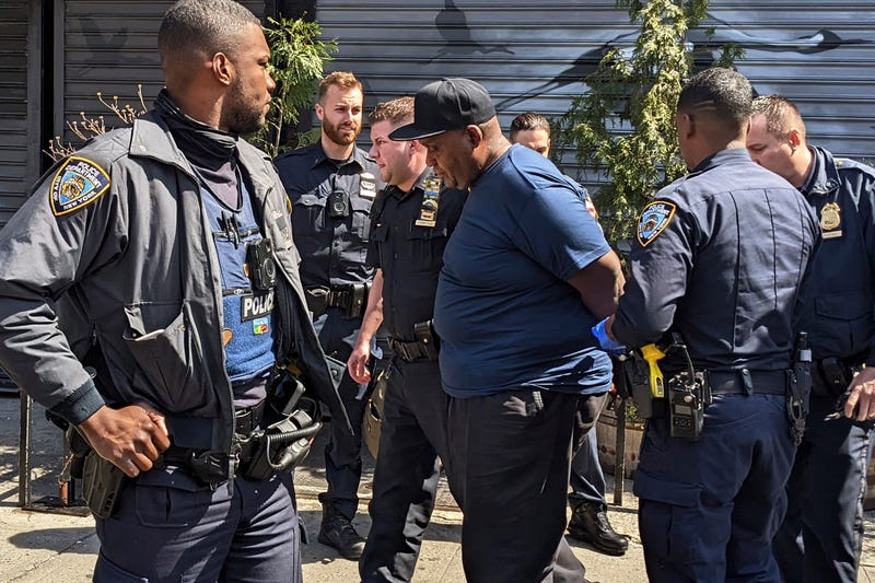 NYPD officers handcuff subway shooting suspect Frank R. James, 62, in the East Village section, of New York, Wednesday, April 13, 2022