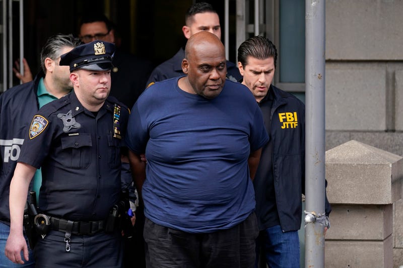 New York City Police and law enforcement officials lead subway shooting suspect Frank R. James, 62, center, away from a police station, in New York, Wednesday, April 13, 2022