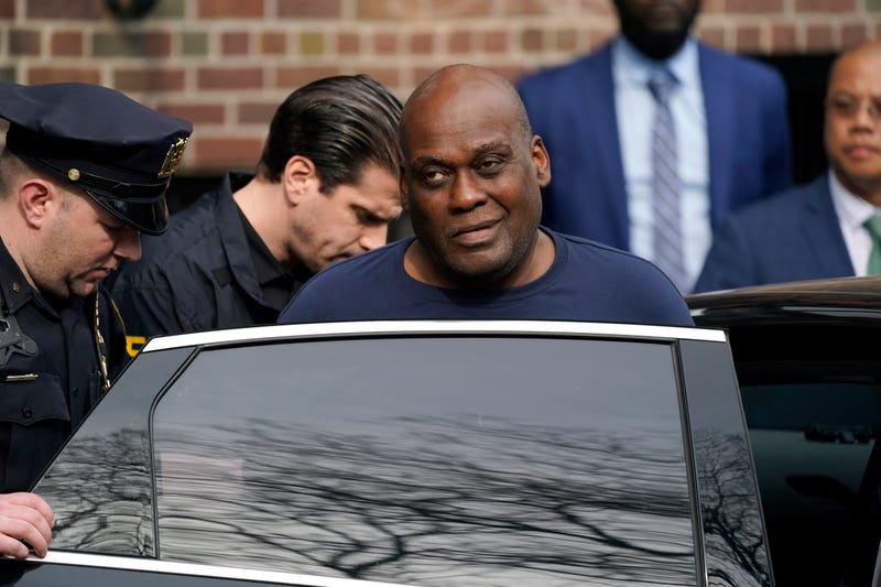 Law enforcement officials lead subway shooting suspect Frank R. James, 62, center right, away from a police station and into a vehicle, in New York, Wednesday, April 13, 2022