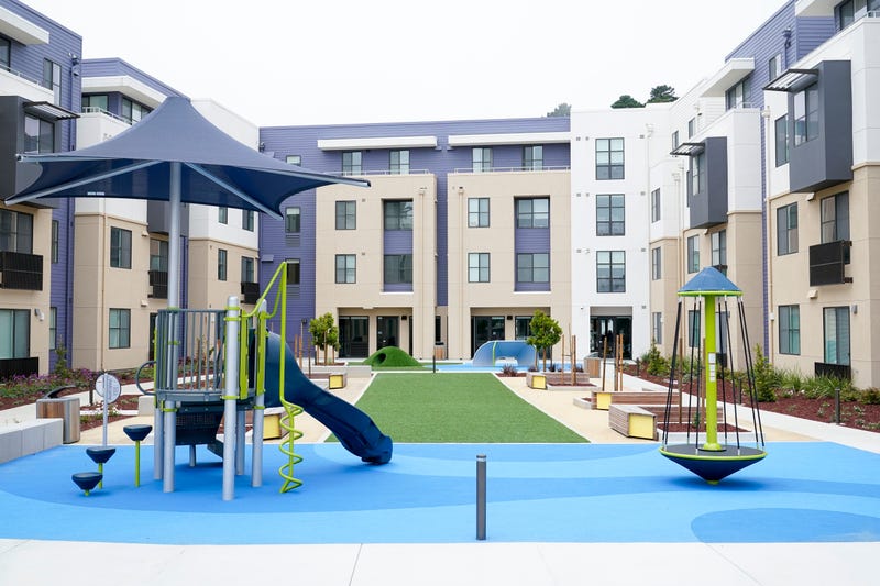 A children's playground is part of the courtyard of a new housing complex for Jefferson Union High School District