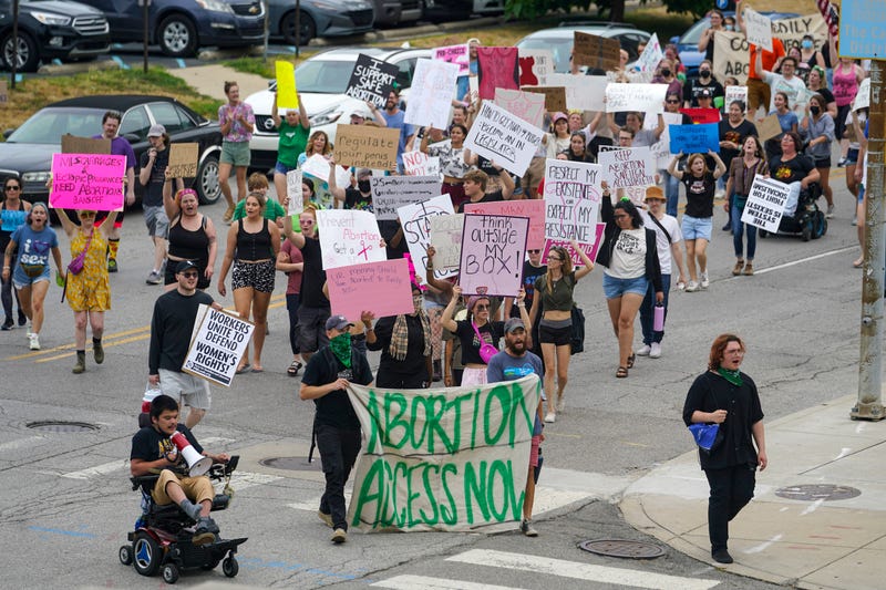 demonstrators march outside of the Indiana Statehouse