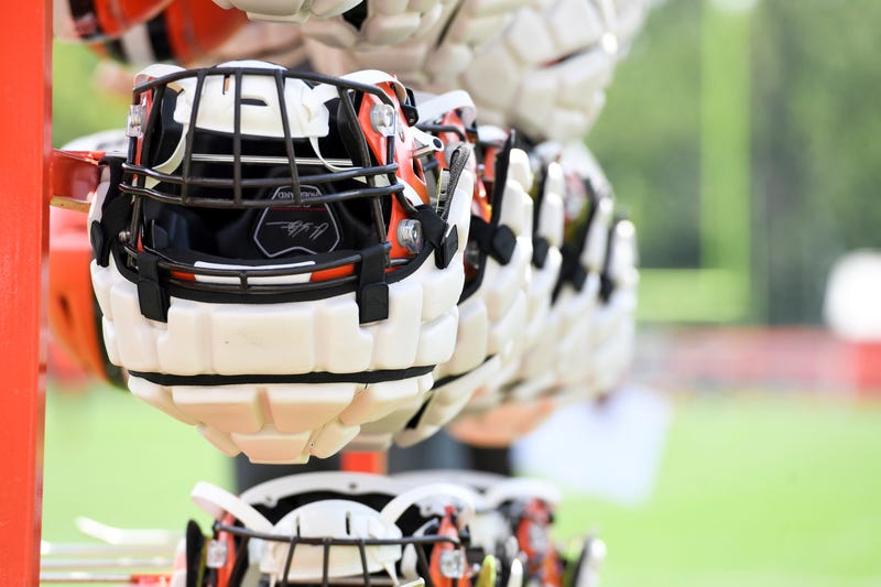 Cleveland Browns helmets, with Guardian Caps, hang from a rack during the NFL football team's training camp, Thursday, July 28, 2022, in Berea, Ohio.