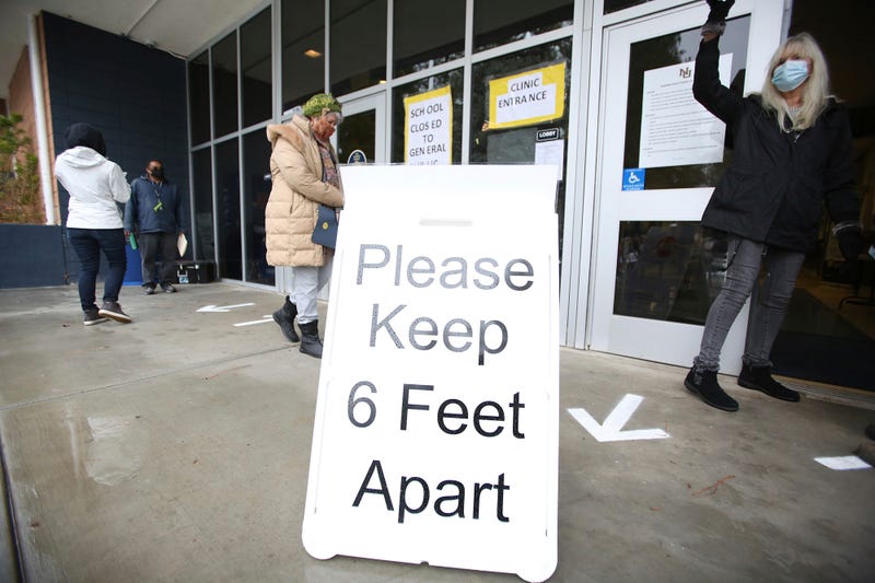 A sign asks those getting vaccinated to keep 6 feet apart during the vaccination event, Wednesday, Jan. 27, 2021, at Nevada Union High School in Grass Valley, Calif. The CDC has again revised its COVID guidelines, further relaxing quarantine recommendations and dropping the recommendation that people stay at least 6 feet away from each other.