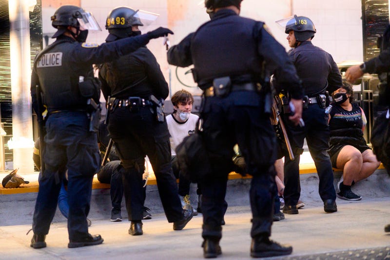 FILE - Police officers detain demonstrators in Oakland, Calif., on June 1, 2020. Alameda County has agreed to ban rubber bullets, bean bags and less-lethal munitions for crowd control as part of a settlement with two protesters who sued after being injured by rubber bullets fired by sheriff's deputies during 2020 protests in Oakland against police brutality, the plaintiff's lawyer said Thursday, Sept. 1, 2022.