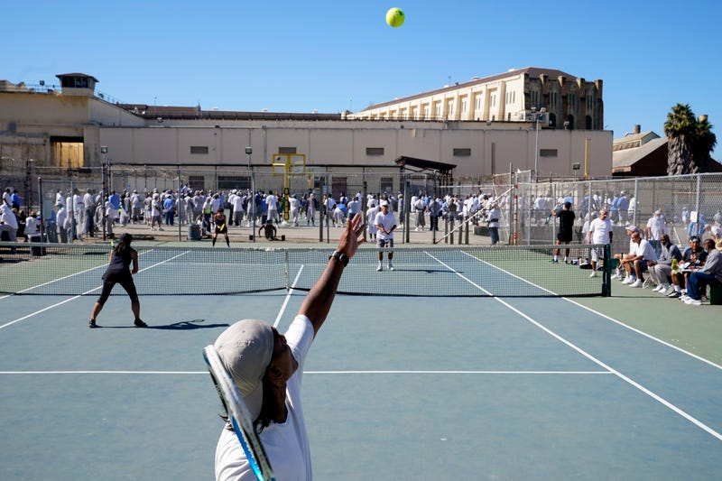 James Duff, bottom, serves during a tennis match between fellow San Quentin State Prison inmates and visiting players in San Quentin, Calif., Saturday, Aug. 13, 2022.