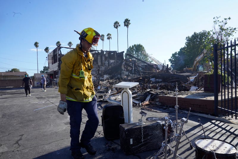 A Los Angeles fireman recovers musicals instruments following a fire at the Victory Baptist Church in Los Angeles, Sunday, Sept. 11, 2022. Authorities say an arson investigation is under way after a fire destroyed the historic church in South Los Angeles.