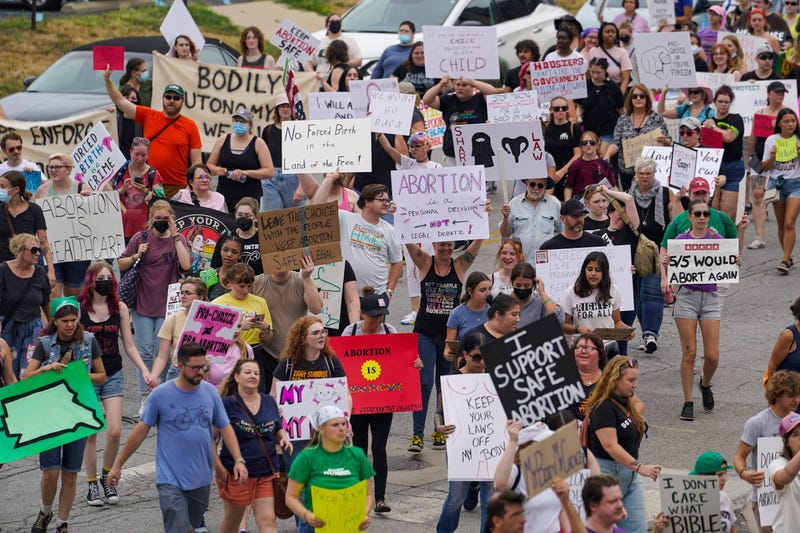 Pro abortion activists march between the Indiana Statehouse and the Indiana State Library.
