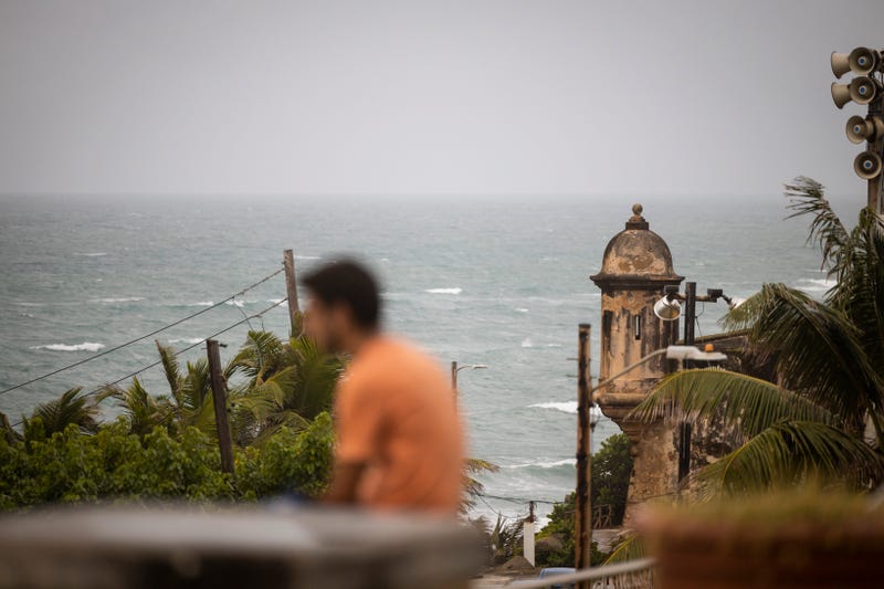 A man stands in front of a beach before the arrival of Tropical Storm Fiona in San Juan, Puerto Rico, Saturday, Sept. 17, 2022.