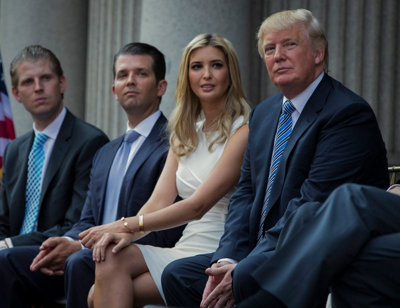 FILE - Donald Trump, right, sits with his children, from left, Eric Trump, Donald Trump Jr., and Ivanka Trump during a groundbreaking ceremony for the Trump International Hotel on July 23, 2014, in Washington. New York’s attorney general sued former President Donald Trump and his company on Wednesday, Sept. 21, 2022, alleging business fraud involving some of their most prized assets, including properties in Manhattan, Chicago and Washington, D.C.