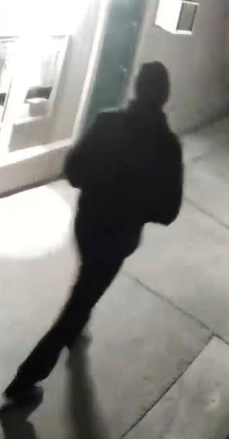 In this undated surveillance image released by the Stockton Police Department, a grainy still image of a “person of interest," dressed all in black and wearing a black cap, who appeared in videos from several of the homicide crime scenes in Stockton. Ballistics tests have linked the fatal shootings of six men and the wounding of one woman in California— all potentially at the hands of a serial killer — in crimes going back more than a year, police said Monday.