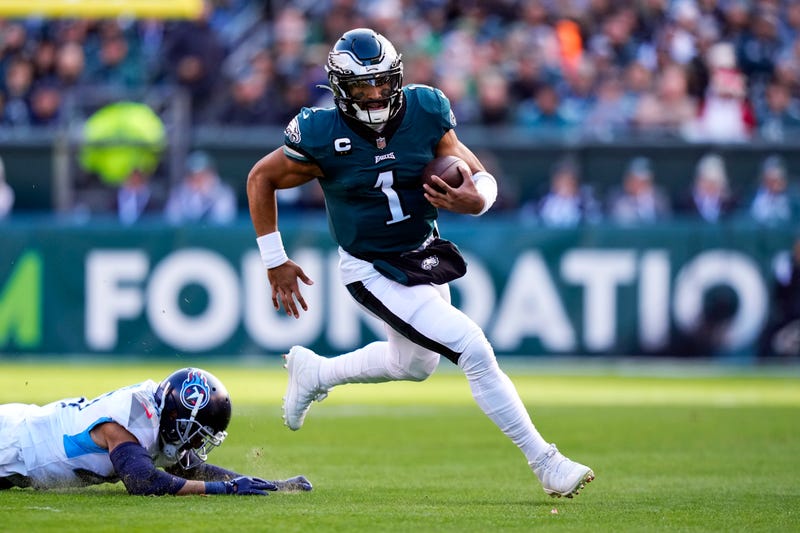 Philadelphia Eagles' Jalen Hurts runs past Tennessee Titans' Andrew Adams during the first half of an NFL football game, Sunday, Dec. 4, 2022, in Philadelphia.