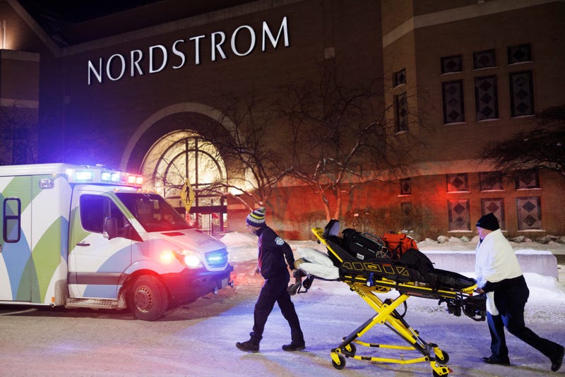 Two first responders and an ambulance are seen at the entrance to Nordstrom at the Mall of America in Bloomington, Minn., after reports of shots fired on Friday, Dec. 23, 2022.