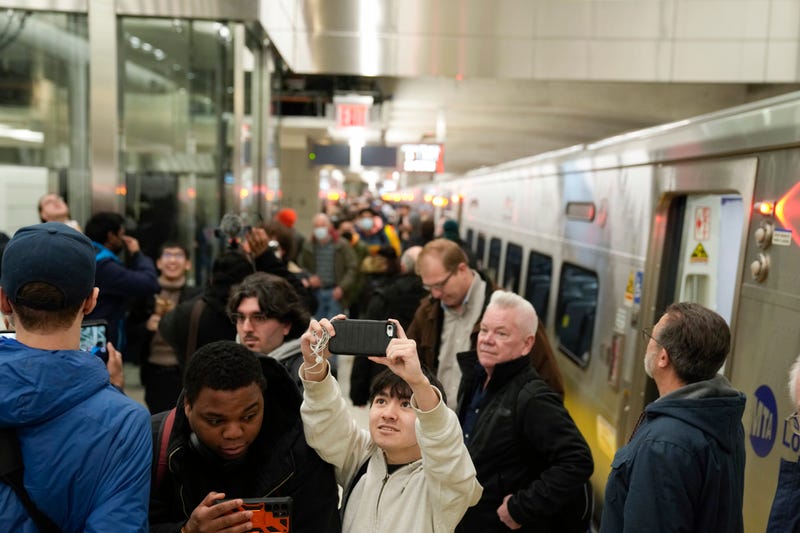 Riders take photos and videos as they exit the first Long Island Railroad train to arrive in Grand Central Station in New York, Wednesday, Jan. 25, 2023.
