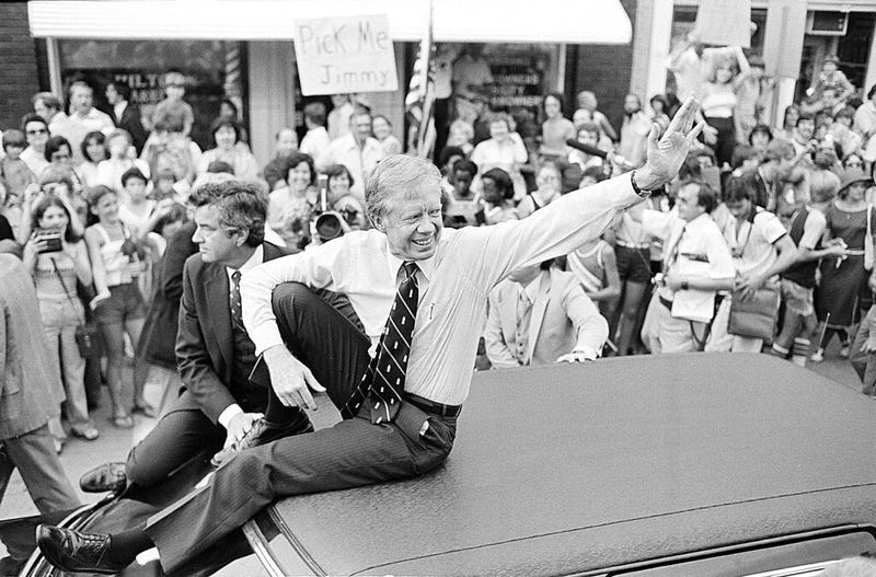 President Jimmy Carter waves from the roof of his car along a parade route through Bardstown, Kentucky, July 31, 1979.