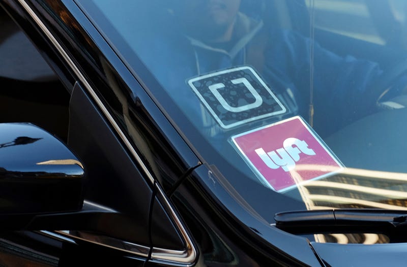 FILE - In this Jan. 12, 2016, file photo, a ride share car displays Lyft and Uber stickers on its front windshield in downtown Los Angeles. A California appeals court ruled Monday, March 13, 2023, that a voter-backed initiative exempting Uber and Lyft from a key provision of state employment law is constitutional, a reversal of a lower court decision that marks a win for the ride-hailing giants.