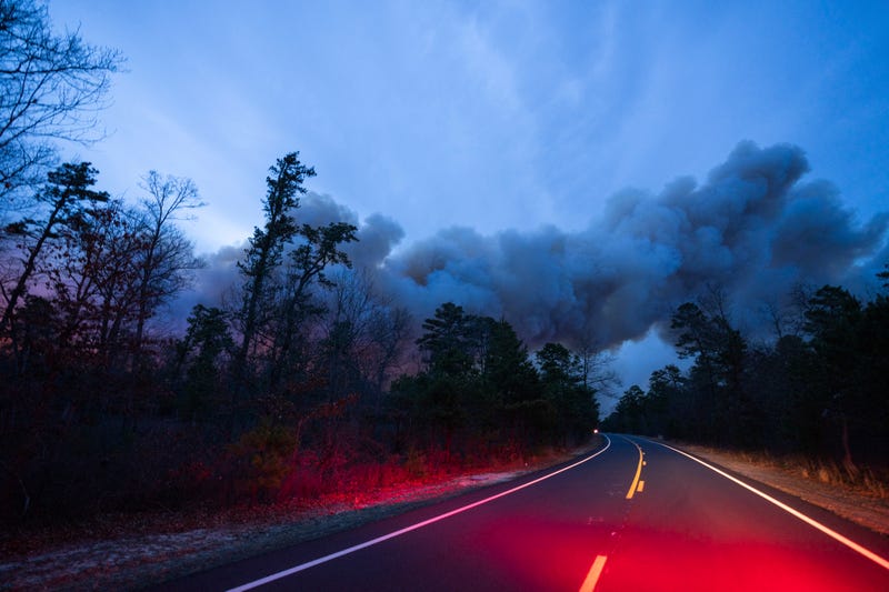 In this photo provided by the New Jersey Department of Environmental Protection, a massive 2,500-acre forest fire burns in Ocean County, N.J., early Wednesday, April 12, 2023, as firefighters battle the blaze