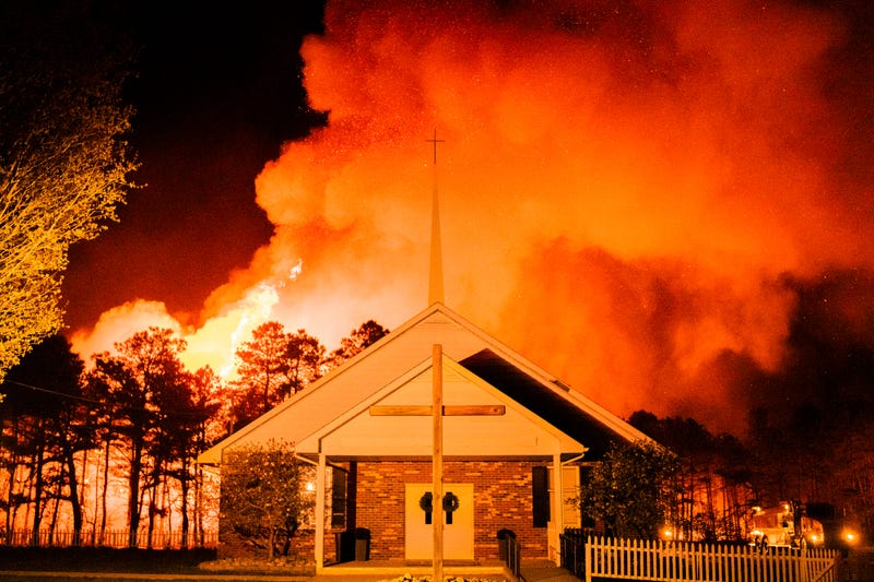 In this photo provided by the New Jersey Department of Environmental Protection, a massive 2,500-acre forest fire burns in Ocean County, N.J., early Wednesday, April 12, 2023, as firefighters battle the blaze