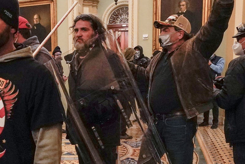 U.S. Capitol Police officers confront rioters, including Dominic Pezzola, center with police shield, outside the Senate Chamber inside the Capitol, Wednesday, Jan. 6, 2021, in Washington.