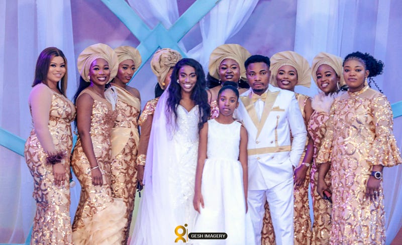 In this photo provided by Gesh Creatives, Eunice Dwumfour, center left, stands with daughter Nicole, 11, husband and fellow pastor Peter Ezechukwu and other loved ones at her Nov. 24, 2022 wedding ceremony at Champions Royal Assembly in Abuja, Nigeria