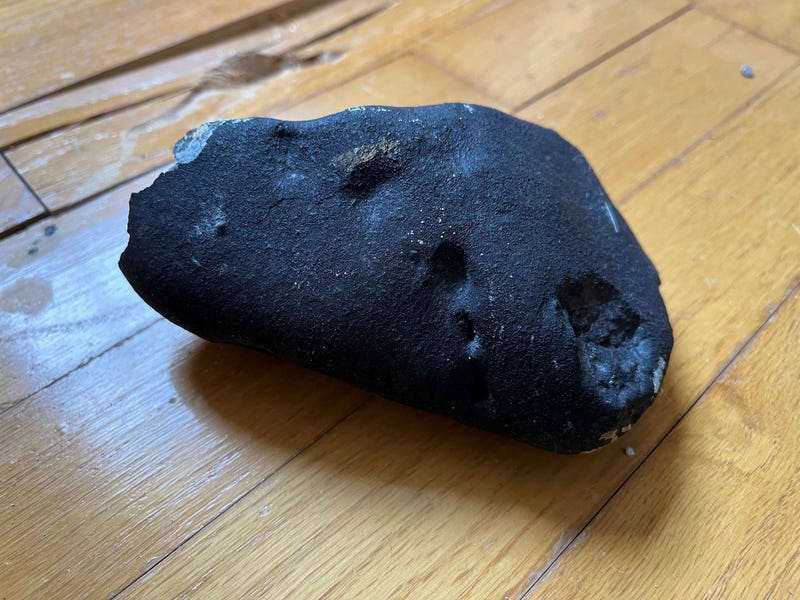 This image provided by Hopewell Township Police Department shows a metallic object believed to be a meteorite on a hardwood floor at a residence in Hopewell Township, N.J.