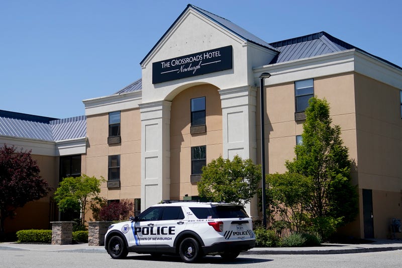 Security stands at the doors of The Crossroads Hotel where two busloads of migrants arrived hours earlier, Thursday, May 11, 2023, in Newburgh, N.Y