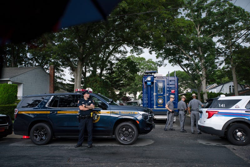 Police officers stand guard near the house where a suspect has been taken into custody on New York's Long Island in connection with a long-unsolved string of killings, known as the Gilgo Beach murders, Friday, July 14, 2023, in Massapequa Park, N.Y.