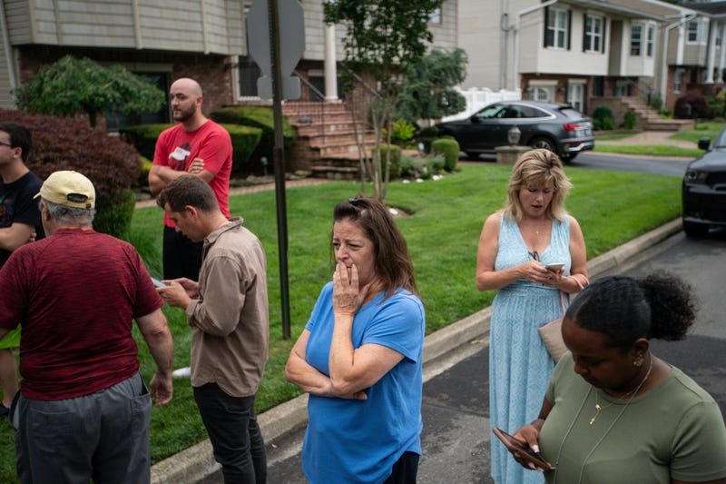 Residents try to take a look as police officers search the house where a suspect has been taken into custody on New York's Long Island in connection with a long-unsolved string of killings, known as the Gilgo Beach murders, Friday, July 14, 2023, in Massapequa Park, N.Y.