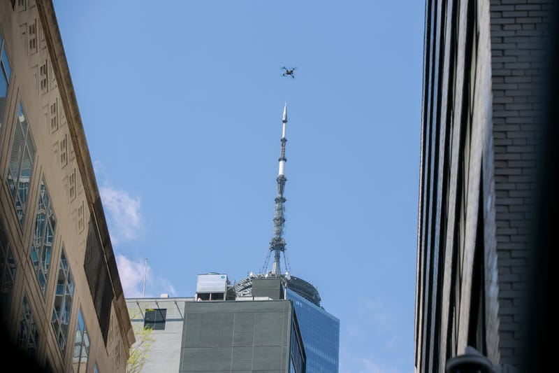 An NYPD or FDNY drone flies over the site of a partially collapsed parking garage as One World Trade Center is visible in the background in New York City, April 19, 2023