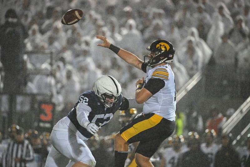 Penn State defensive tackle Jordan van den Berg (52) pressures Iowa quarterback Deacon Hill (10) during the second half of an NCAA college football game as rain falls on Saturday, Sept. 23, 2023, in State College, Pa. 