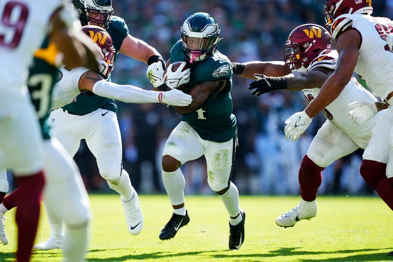Philadelphia Eagles running back Kenneth Gainwell (14) runs with the ball under pressure from the Washington Commanders during the second half of an NFL football game Sunday, Oct. 1, 2023, in Philadelphia.