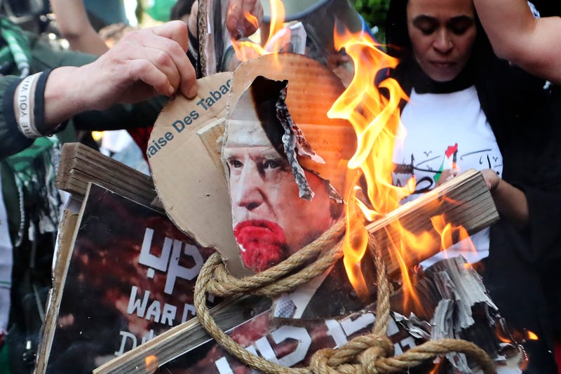 Palestinian protesters burn pictures that show U.S. President Joe Biden during a protest in solidarity with the Palestinian people in Gaza, at the Palestinian refugee camp of Ein el-Hilweh, south Lebanon, Wednesday, Oct. 18, 2023.
