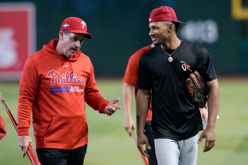 Philadelphia Phillies manager Rob Thomson, left, talks with Johan Rojas after a short workout Wednesday, Oct. 18, 2023, in Phoenix. The Phillies will play Game 3 against the Arizona Diamondbacks in the baseball NL Championship Series on Thursday. (AP Photo/Ross D. Franklin)