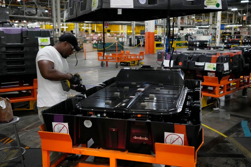 assembly line worker uncrates an LG battery