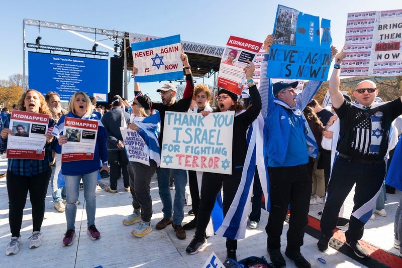 Participants hold signs as they stand on the National Mall at the March for Israel on Tuesday, Nov. 14, 2023, in Washington.