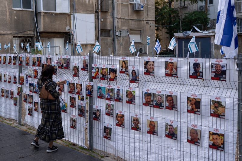 woman looks at photographs of hostages