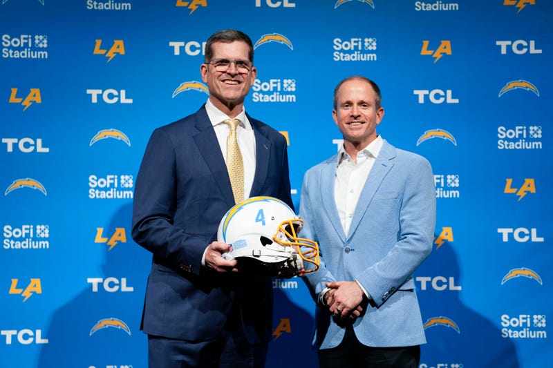 Jim Harbaugh, left, poses for photos with President of Business Operations John Spanos during a press conference introducing him as the new head coach of the Los Angeles Chargers NFL football team, Thursday, Feb. 1, 2024, in Inglewood, Calif. 