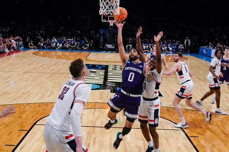 Northwestern's Boo Buie (0) drives past UConn's Hassan Diarra (10) during the first half of a second-round college basketball game in the NCAA Tournament Sunday, March 24, 2024, in New York.
