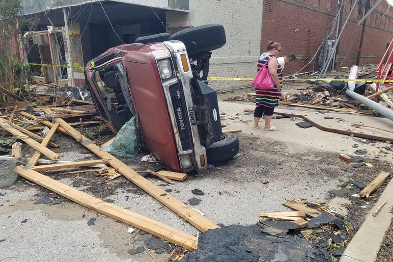 A car lies on its side after being knocked over during a tornado that tore through downtown Sulphur, Okla.