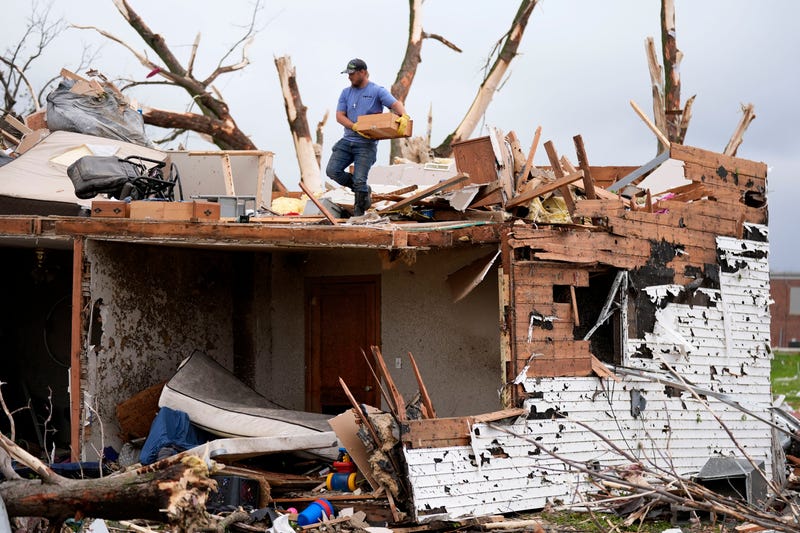 A man sorts through the remains of a home damaged by a tornado Tuesday, May 21, 2024, in Greenfield, Iowa. 