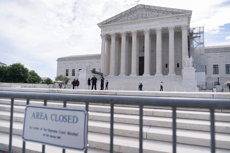 Law enforcement officers stand behind barricades outside the Supreme Court on Thursday, June 27, 2024, in Washington.