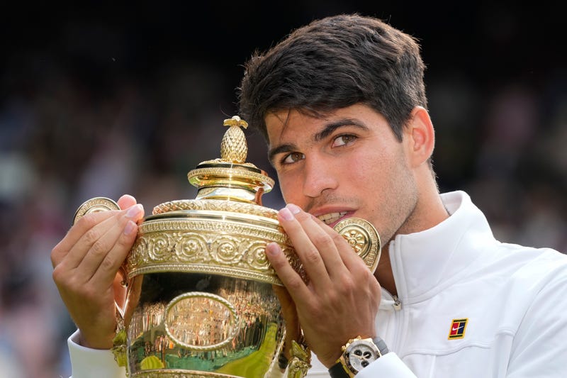 Carlos Alcaraz of Spain holds his trophy after defeating Novak Djokovic of Serbia in the men's singles final at the Wimbledon tennis championships in London, Sunday, July 14, 2024.