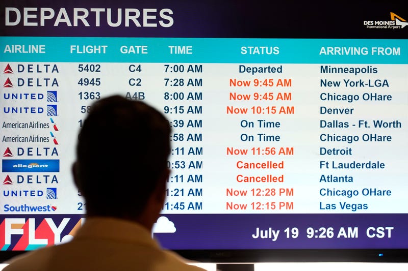 A passenger looks at a departures monitor at the Des Moines International Airport, Friday, July 19, 2024, in Des Moines, Iowa