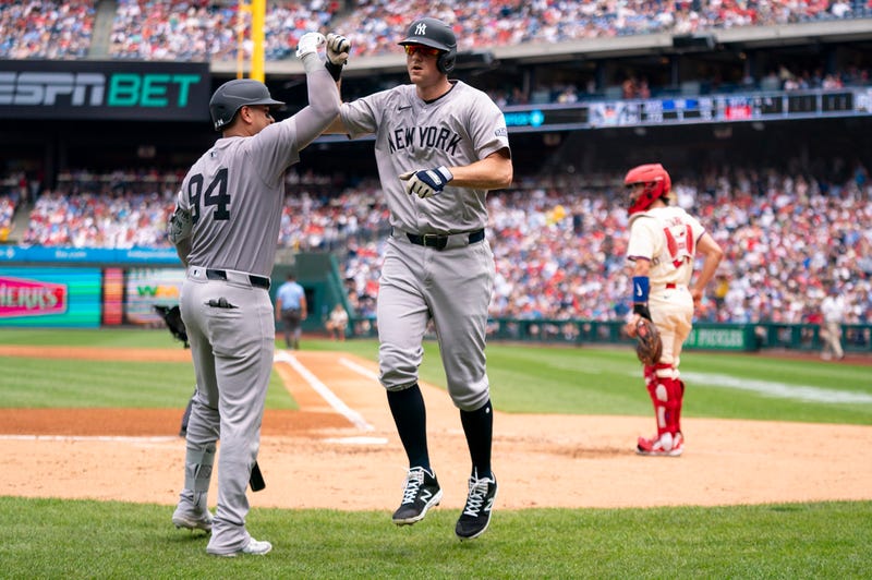New York Yankees' DJ LeMahieu, center, celebrates his grand slam with Carlos Narvaez, left, as Philadelphia Phillies catcher Garrett Stubbs, right, looks on during the second inning of a baseball game, Wednesday, July 31, 2024, in Philadelphia.
