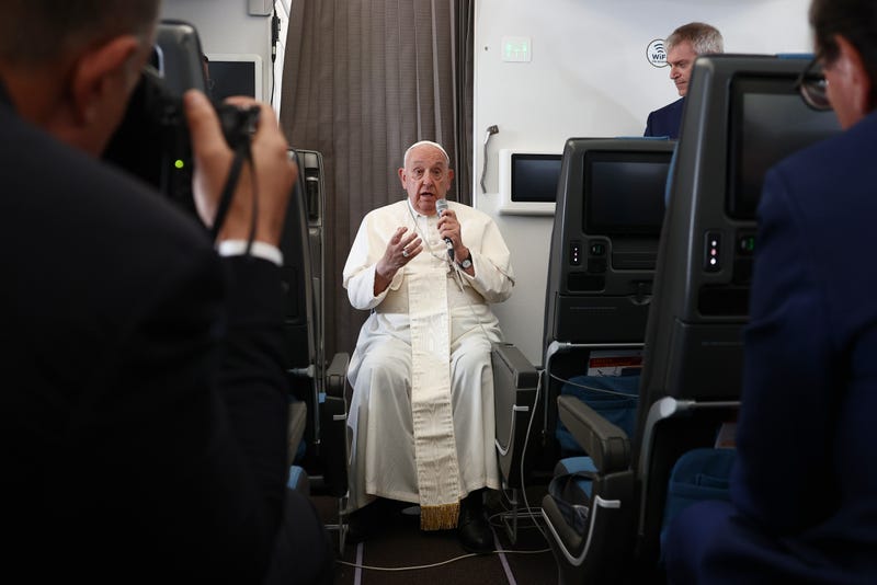 Pope Francis holds a news conference aboard the papal plane on his flight back after his 12-day journey across Southeast Asia and Oceania, Friday, Sept. 13, 2024.