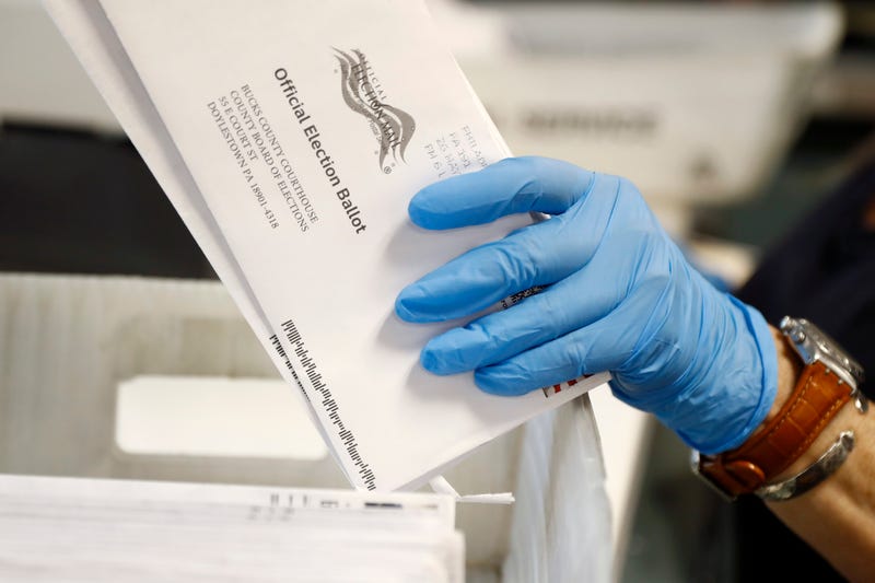 A worker processes mail-in ballots at the Bucks County Board of Elections office prior to the primary election in Doylestown, Pa., May 27, 2020.