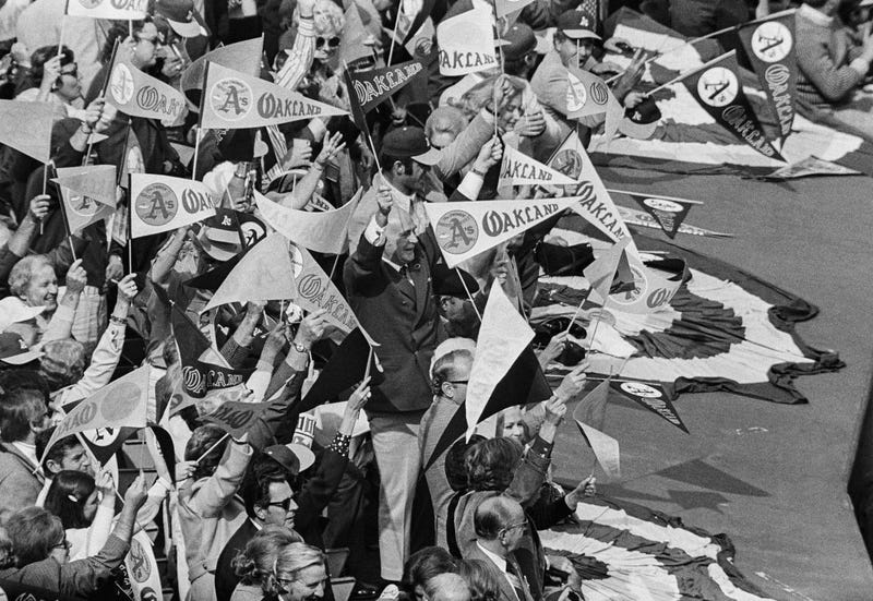  Owner Charles Finley, center, waves a pennant along with a group of fans, as they cheer on the Oakland As, after catcher Gene Tenace connected for his fourth home run of the World Series, Oct. 20, 1972, Oakland, Calif.