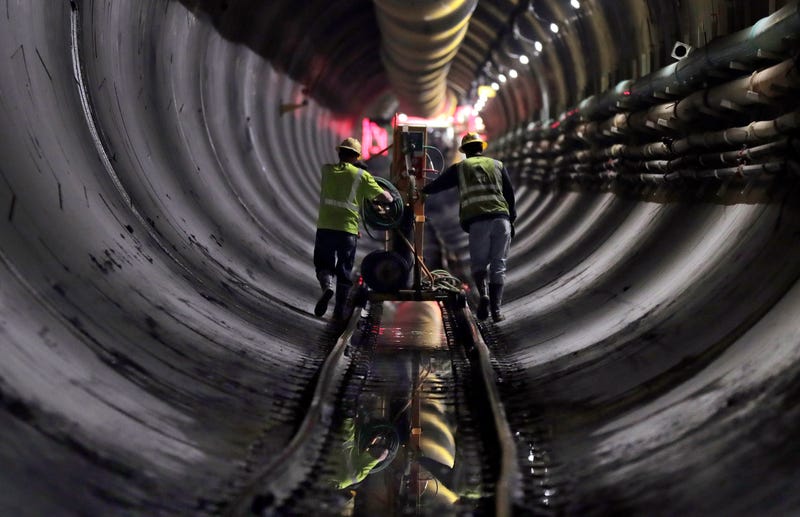 Tunnel workers push equipment up a rail track to a machine boring a 2.5-mile bypass tunnel for the Delaware Aqueduct in Marlboro, N.Y., May 16, 2018