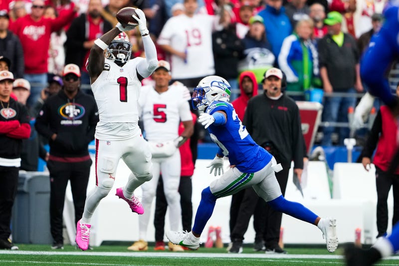 San Francisco 49ers wide receiver Deebo Samuel Sr. (1) makes a catch against Seattle Seahawks safety Julian Love, right, and would run it in for a touchdown during the first half of an NFL football game, Thursday, Oct. 10, 2024 in Seattle.